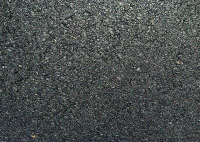 Close-up view of a textured, black asphalt surface.
